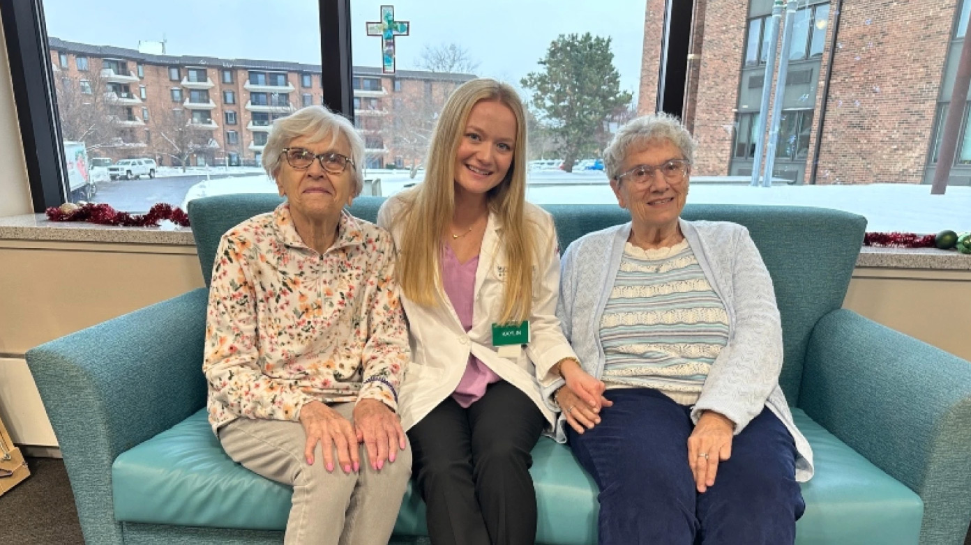MSU medical student Kailyn Burton sitting with Holland Home residents